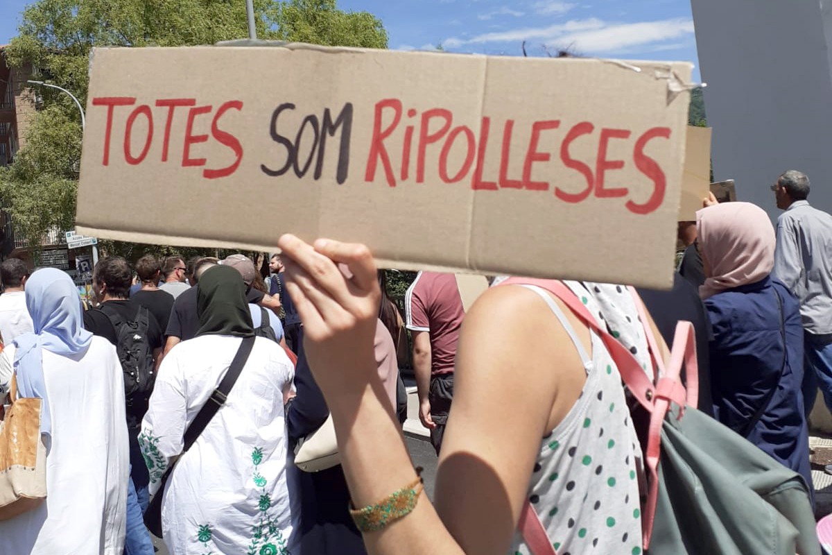 Una dona mostra un cartell reivindicant la ciutadania de Ripoll de totes les persones que hi viuen en una manifestació el dia de la constitució del nou Ajuntament