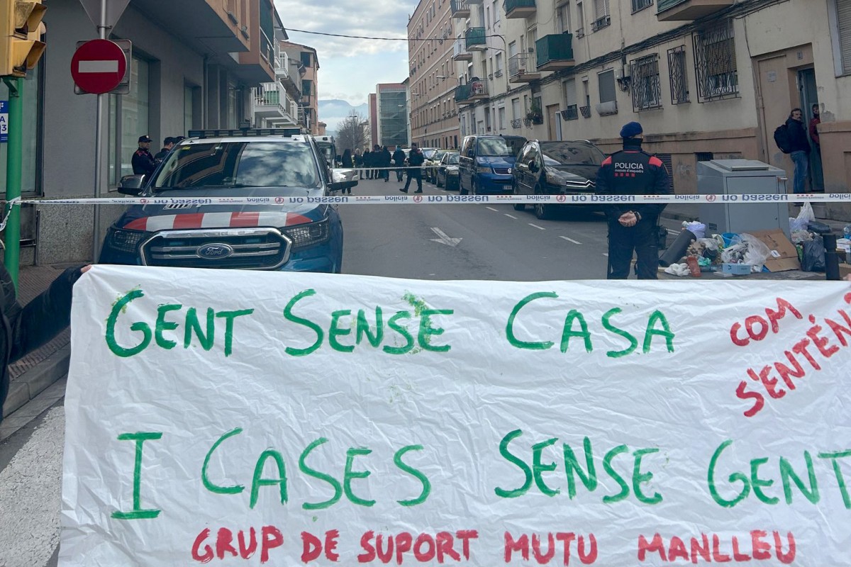 Pancartes de protesta davant el cordó policial que ha impedit l'accés de les activistes pel dret a l'habitatge al domicili on s'estava fent el desnonament