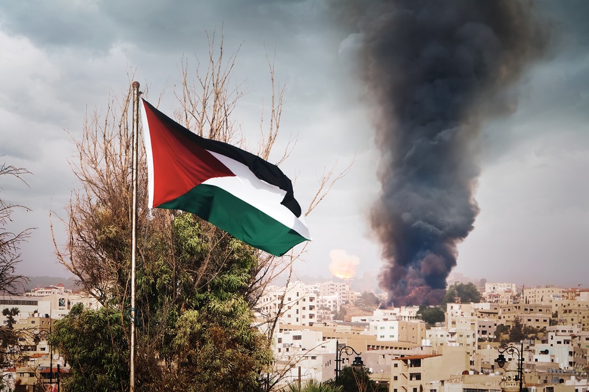La bandera palestina onejant en una ciutat en flames