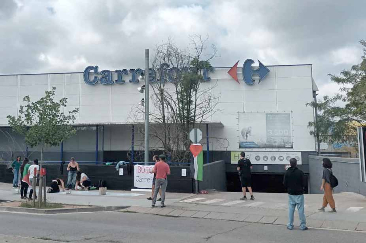 Activistes pro-Palestina davant del Carrefour de Vic on informen la clientela de la complicitat del supermercat amb el genocidi de Gaza
