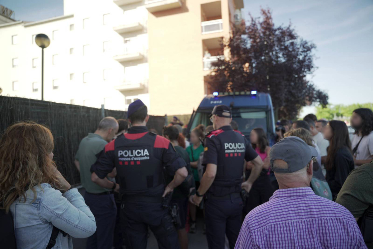Activistes, mossos i comissió judicial, davant l'edifici d'on s'ha desnonat la família