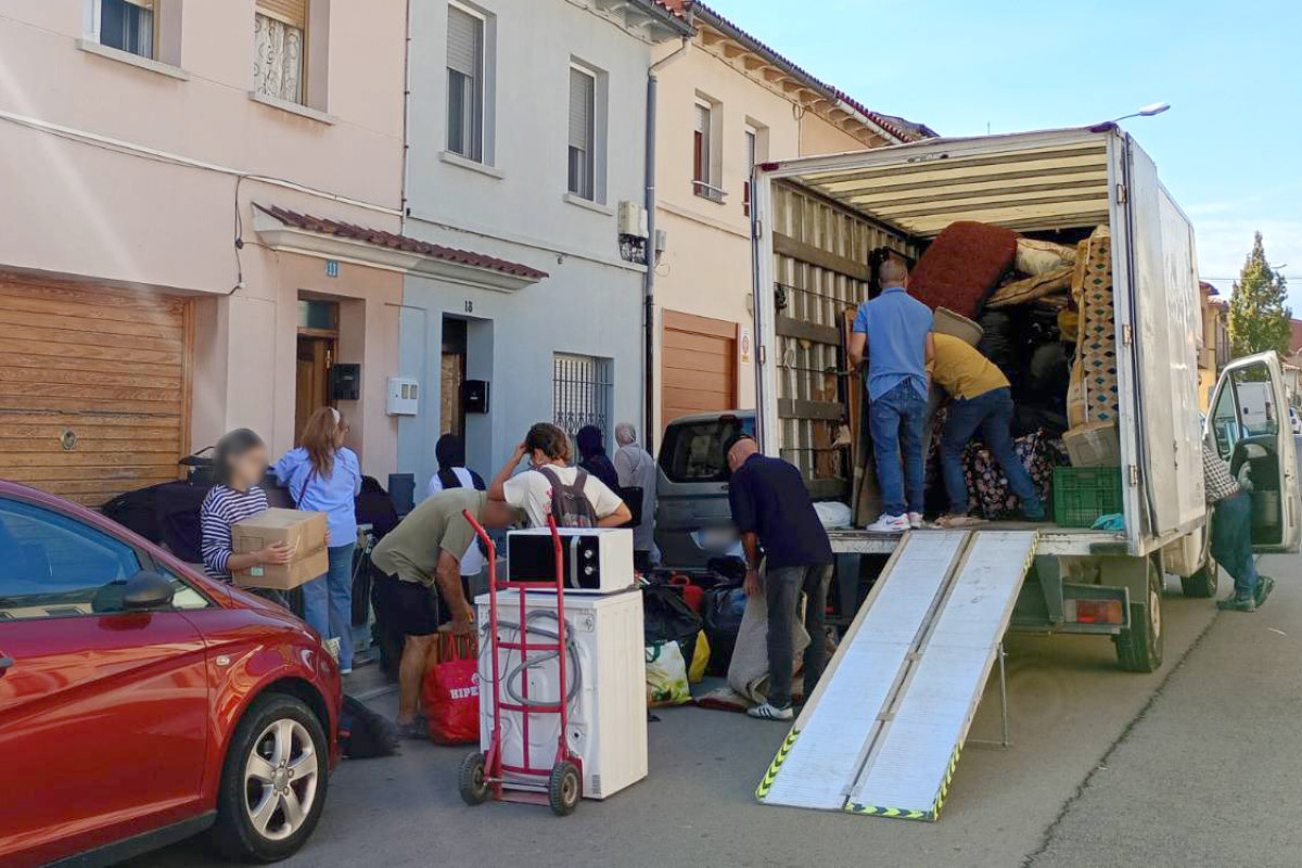 Activistes pel dret a l'habitatge amb familiars i amistats del matrimoni afectat carregant a corre-cuita les seves pertinences en un camió